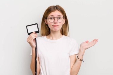 Kızıl saçlı güzel kız şaşkın, şaşkın ve şüpheci hissediyor. VIP geçiş kartı konsepti