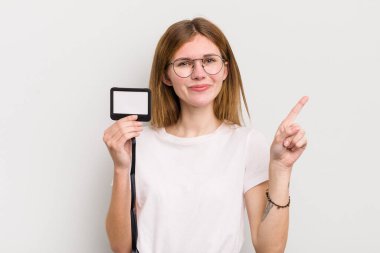 kızıl saçlı güzel kız gülümsüyor ve arkadaş canlısı görünüyor, bir numarayı gösteriyor. VIP geçiş kartı konsepti