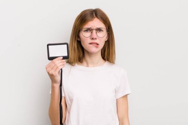 Kızıl saçlı güzel kız şaşkın ve şaşkın görünüyor. VIP geçiş kartı konsepti