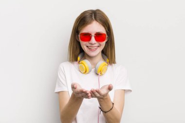 kızıl saçlı güzel bir kız arkadaşça gülümsüyor ve bir konsept sunuyor. müzik konseptini dinle