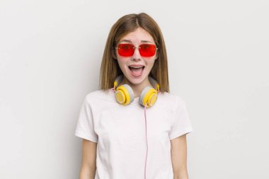 Kızıl saçlı güzel kız çok şaşırmış ya da şaşkın görünüyor. müzik konseptini dinle