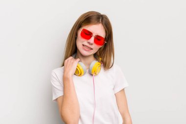 Kızıl saçlı güzel kız stresli, endişeli, yorgun ve hayal kırıklığına uğramış hissediyor. müzik konseptini dinle