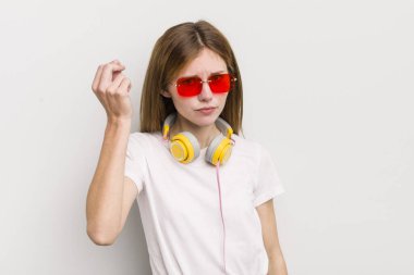 Kızıl saçlı güzel kız kapiş ya da para hareketi yapıyor, sana ödemeni söylüyor. müzik konseptini dinle