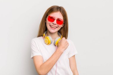 Kızıl saçlı güzel kız kendini mutlu hissediyor ve bir meydan okumayla yüzleşiyor ya da kutluyor. müzik konseptini dinle