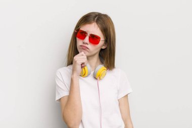 Kızıl saçlı güzel kız düşünüyor, kuşkulu ve şaşkın hissediyor. müzik konseptini dinle
