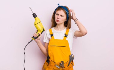 Kızıl saçlı güzel kız şaşkın ve kafası karışık, kaşınan kafa. konut yenileme konsepti