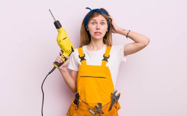 Kızıl saçlı güzel kız stresli, endişeli ya da korkmuş, elleri başının üstünde. konut yenileme konsepti