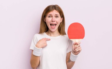 kızıl saçlı güzel kız mutlu hissediyor ve heyecanla kendini işaret ediyor. ping pong konsepti