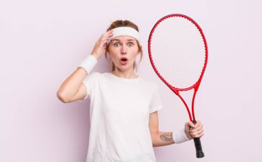 kızıl saçlı güzel kız mutlu, şaşkın ve şaşırmış görünüyor. tenis konsepti