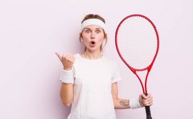 Kızıl saçlı güzel kız inançsızlıktan şaşkın şaşkın bakıyor. tenis konsepti