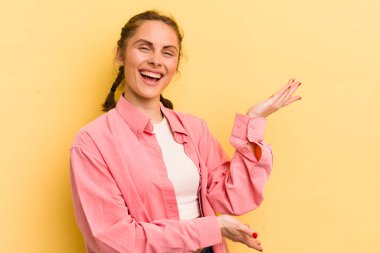 Genç ve güzel bir kadın gururla ve güvenle gülümsüyor, mutlu ve tatmin olmuş hissediyor ve fotokopi alanında bir konsept gösteriyor.