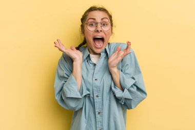 Genç ve güzel bir kadın beklenmedik bir sürpriz yüzünden şaşkın, heyecanlı, gülen, şaşkın ve mutlu hissediyor.