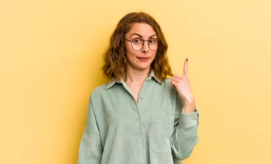 Genç ve güzel bir kadın, harika bir fikri fark ettikten sonra parmağını havaya kaldırıp 