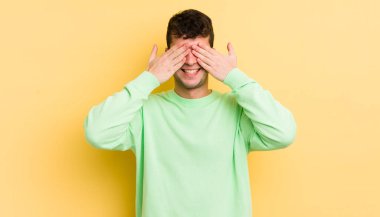 Genç yakışıklı adam gülümsüyor ve mutlu hissediyor, iki eliyle gözlerini kapatıyor ve inanılmaz bir sürpriz bekliyor.