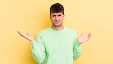 Şaşkın, şaşkın ve stresli görünen genç bir adam. Farklı seçenekler arasında merak ediyor. Belirsiz hissediyor.