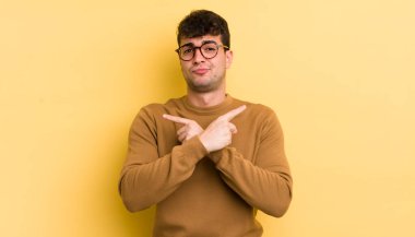 Şaşkın, kafası karışmış, güvensiz ve şüpheyle zıt yönlere bakan genç yakışıklı bir adam.