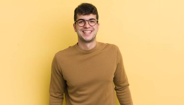 Genç yakışıklı, büyük, dost canlısı, kaygısız bir gülümsemesi olan, pozitif, rahat ve mutlu görünen, ürpertici