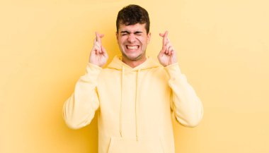 Genç yakışıklı adam gergin ve umutlu, şans diliyor ve dua ediyor.