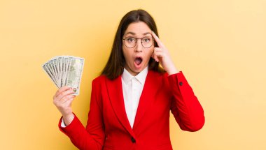 Genç, güzel bir kadın şaşırmış görünüyor, yeni bir düşünce, fikir ya da konsept fark ediyor. para kavramı