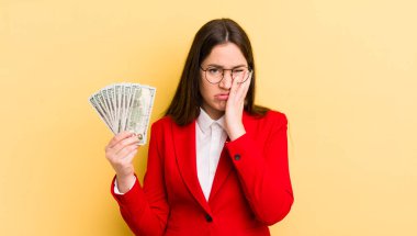 Genç ve güzel bir kadın sıkıcı, bıkkın ve uykulu hissediyor. para kavramı