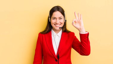 Genç ve güzel bir kadın kendini mutlu hissediyor. Onayını iyi bir hareketle gösteriyor. tele pazarlamacı kavramı