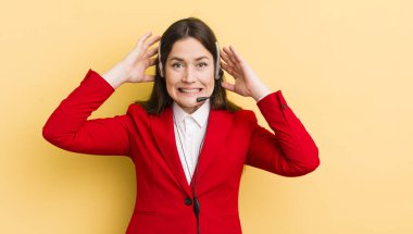 Genç ve güzel bir kadın gergin, endişeli ya da korkmuş hissediyor. Elleri başının üstünde. tele pazarlamacı kavramı