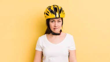 young pretty woman looking puzzled and confused. bike helmet concept