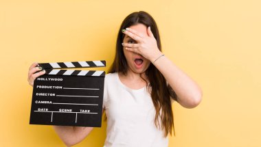 Genç, güzel bir kadın şok olmuş, korkmuş ya da korkmuş görünüyor. Sinema alkışlama konsepti