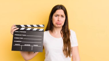 Genç, güzel bir kadın üzgün ve mızmızlanıyor. Mutsuz bir bakışı var ve ağlıyor. Sinema alkışlama konsepti