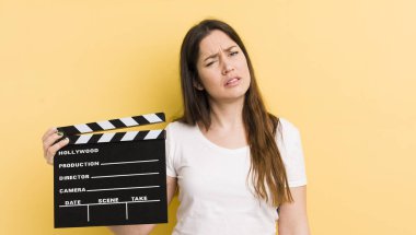 Genç ve güzel bir kadın şaşkın ve şaşkın hissediyor. Sinema alkışlama konsepti