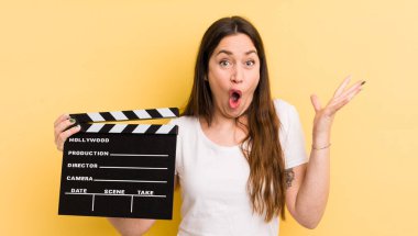 Genç ve güzel bir kadın şok olmuş ve şaşırmış hissediyor. Sinema alkışlama konsepti