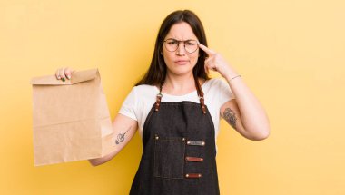 Genç ve güzel bir kadın kafası karışık ve şaşkın hissediyor, deli olduğunu gösteriyor. Fast food kuryesi