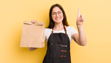 young pretty woman smiling and looking friendly, showing number one. fast food courier