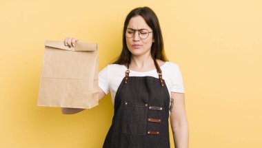 Genç, güzel bir kadın üzgün, üzgün ya da kızgın hissediyor ve yan tarafa bakıyor. Fast food kuryesi