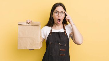 Genç, güzel bir kadın şaşırmış görünüyor, yeni bir düşünce, fikir ya da konsept fark ediyor. Fast food kuryesi