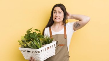 Genç ve güzel bir kadın gergin, endişeli ya da korkmuş hissediyor. Elleri başının üstünde. bitki kavramı