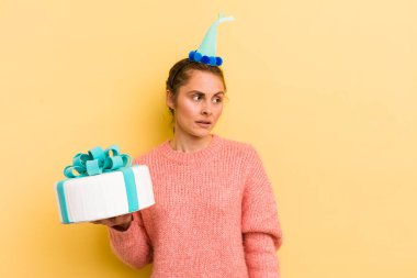 Genç, güzel bir kadın üzgün, üzgün ya da kızgın hissediyor ve yan tarafa bakıyor. doğum günü konsepti