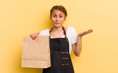 Genç ve güzel bir kadın şaşkın, şaşkın ve şüpheci hissediyor. Fast food kurye konsepti
