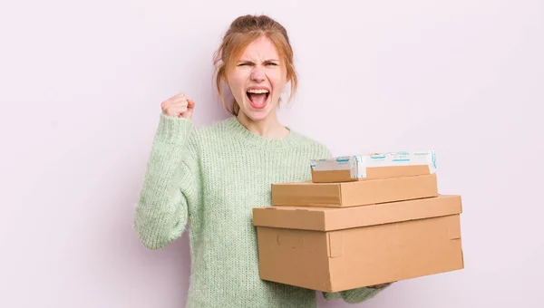 怒りの表情で積極的に叫んでいる赤毛の可愛い女の子 配送ボックスのコンセプト — ストック写真