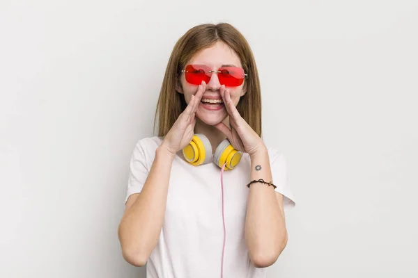 赤毛の可愛い女の子は幸せな気分だ口の横で大きな声を出す 音楽の概念を聞く — ストック写真