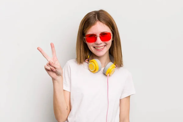 Roodharige Mooie Meid Glimlachend Vriendelijk Toont Nummer Twee Luister Muziek — Stockfoto