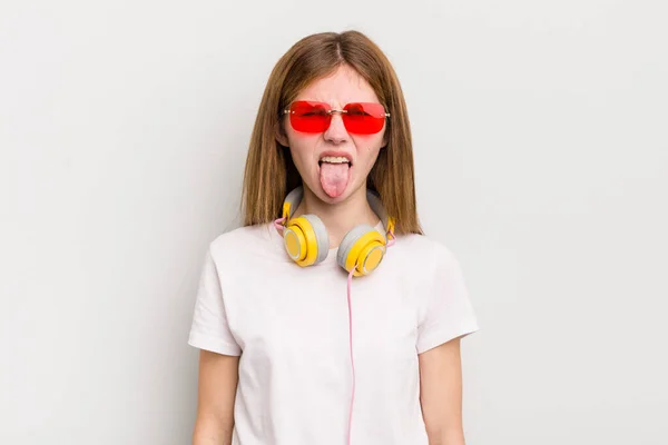 Ruda Ładna Dziewczyna Czuje Obrzydzenie Irytację Język Zewnątrz Słuchaj Muzyki — Zdjęcie stockowe