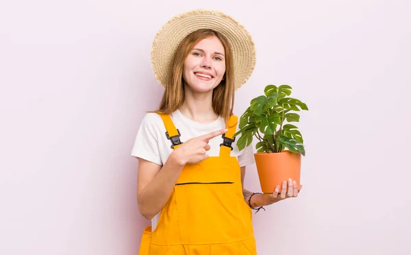 Redhead Pretty Girl Smiling Cheerfully Feeling Happy Pointing Side Plant — Stock Photo, Image