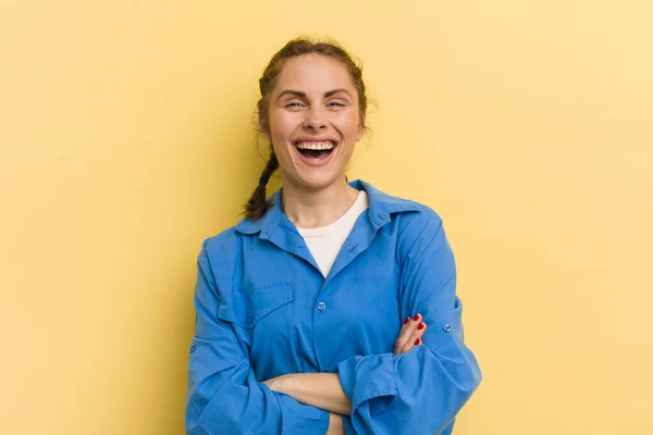 young pretty woman looking like a happy, proud and satisfied achiever smiling with arms crossed