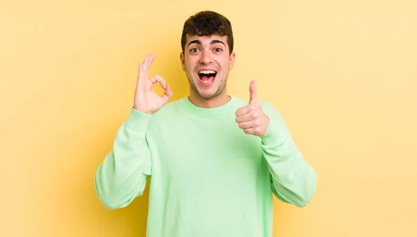 Jovem Homem Bonito Sentindo Feliz Surpreso Satisfeito Surpreso Mostrando Polegares — Fotografia de Stock