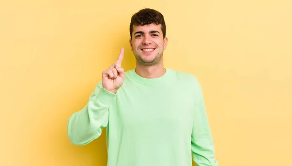 Young Handsome Man Smiling Looking Friendly Showing Number One First — Stock Photo, Image