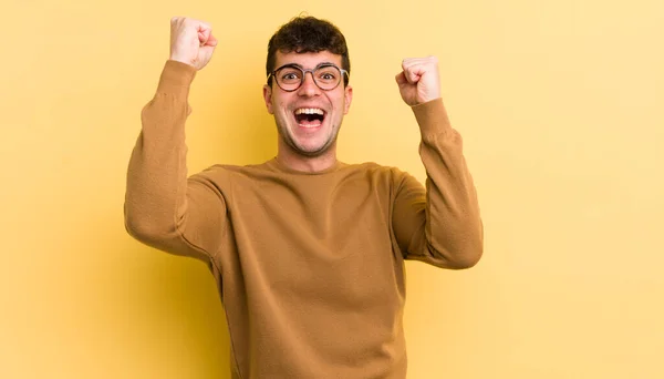 Jovem Bonito Homem Gritando Triunfalmente Parecendo Animado Feliz Surpreso Vencedor — Fotografia de Stock