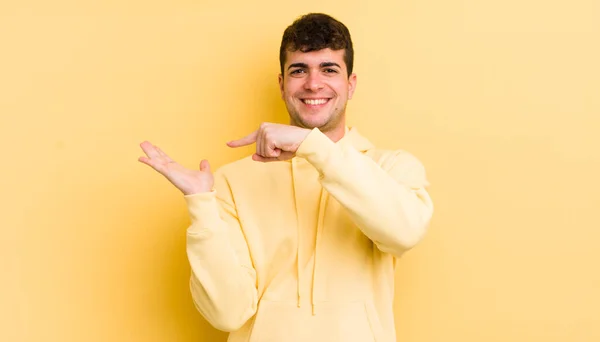 Jovem Homem Bonito Sorrindo Alegremente Apontando Para Copiar Espaço Palma — Fotografia de Stock