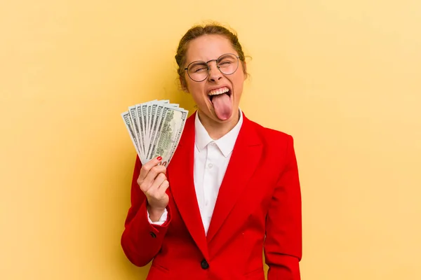 陽気で反抗的な態度の若い可愛い女が冗談を言って舌を出してる お金の概念 — ストック写真