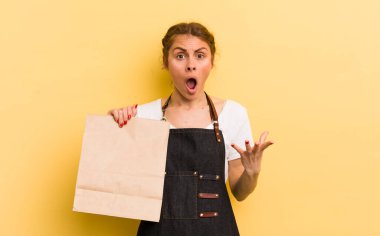 Genç ve güzel bir kadın şok olmuş ve şaşırmış hissediyor. Fast food kurye konsepti